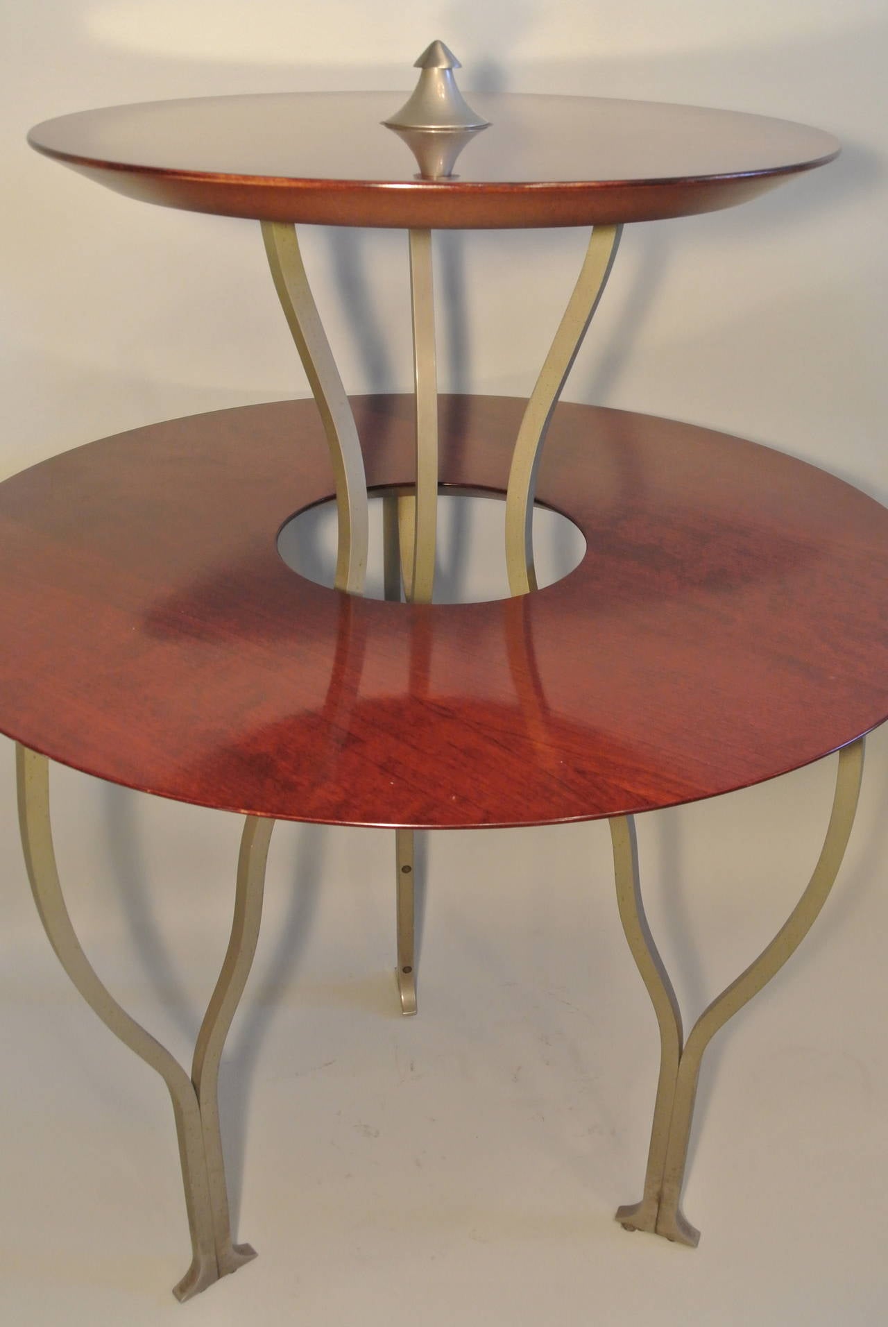 Bi-level round table in solid mahogany (3cm thick) with metal feet from the 20th century. Measure: Height 89cm, width 65cm.