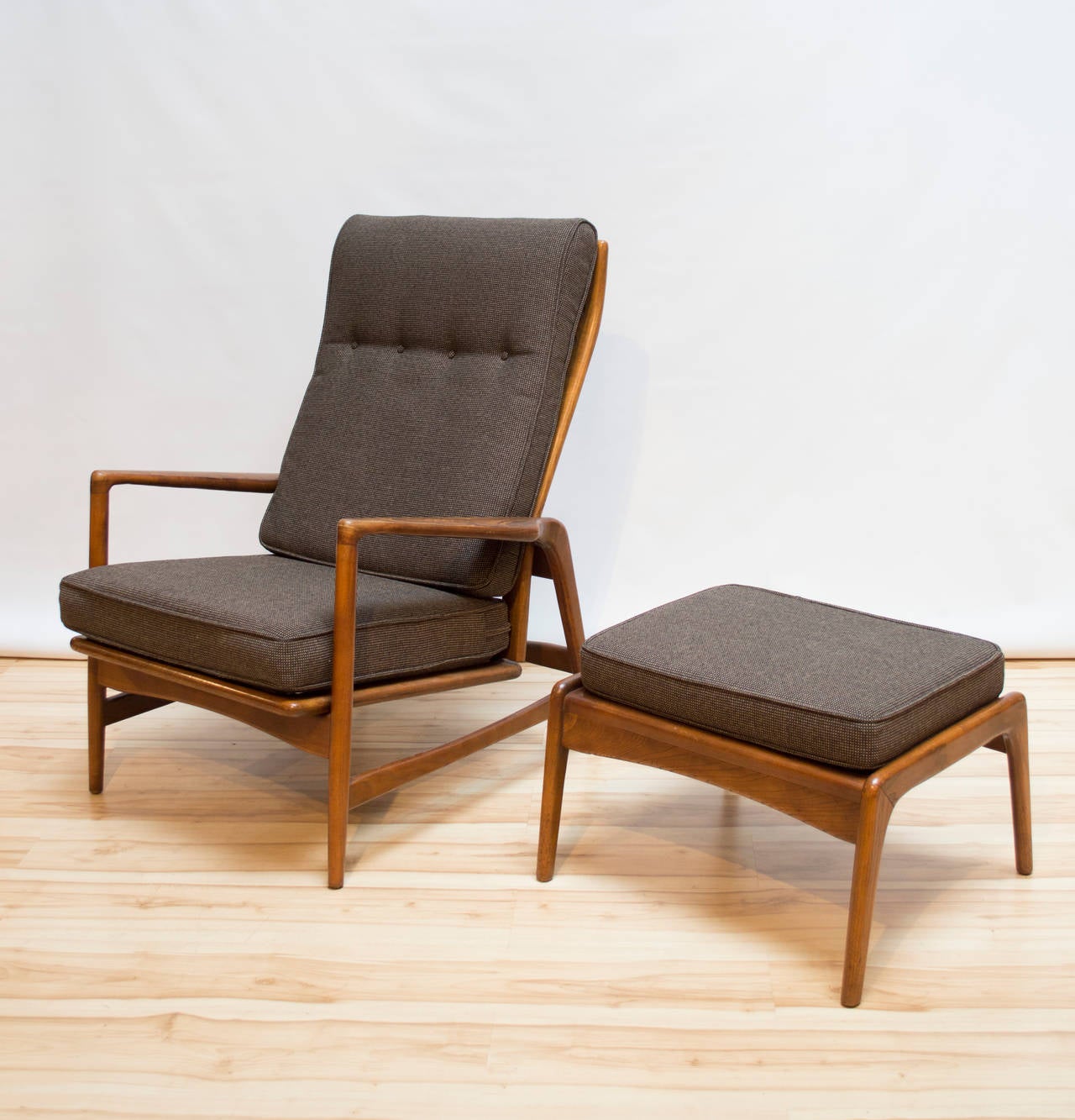 Danish modern oak adjustable reclining lounge chair with ottoman, designed by Ib Kofod-Larsen, circa 1960s. The chair adjusts to four different positions and both the chair and ottoman have been professionally reupholstered in a new dark brown