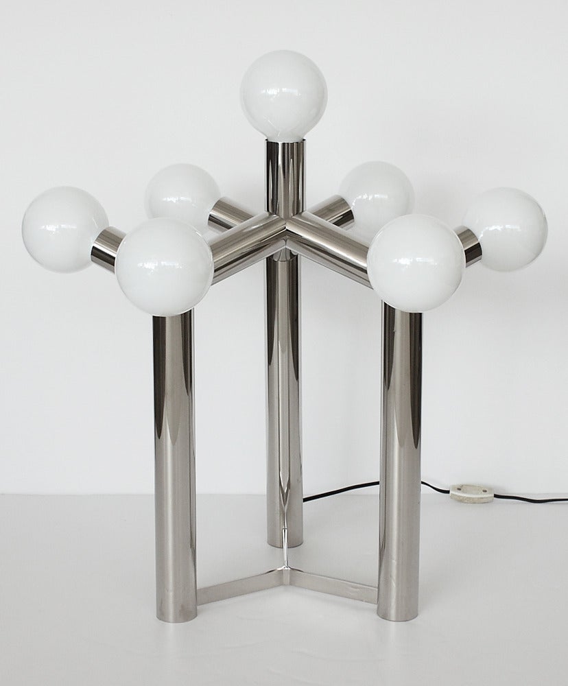 This unique sculptural molecule table lamp features seamless nickel-plated tubular steel construction. In-line switch on cord. Takes seven standard light bulbs. The lamp is in excellent condition with only very minor wear. Working