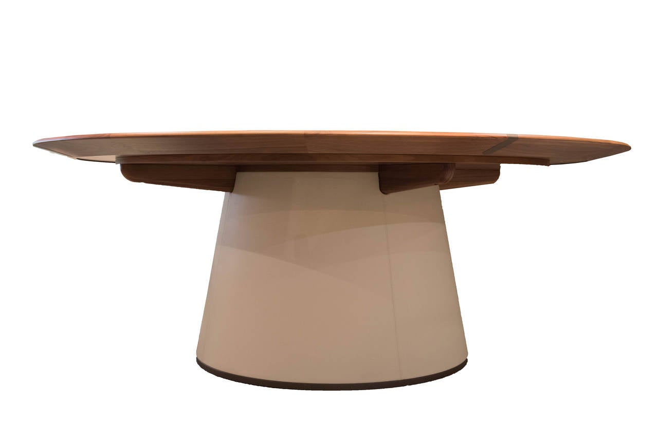 The top structure is in solid, mdf and veneer in walnut Canaletto wood, while the top profile is in solid wood. The Lazy Susan insert is in glacé crystal glass. The central column is covered with leather and the base, as well as the top inserts,