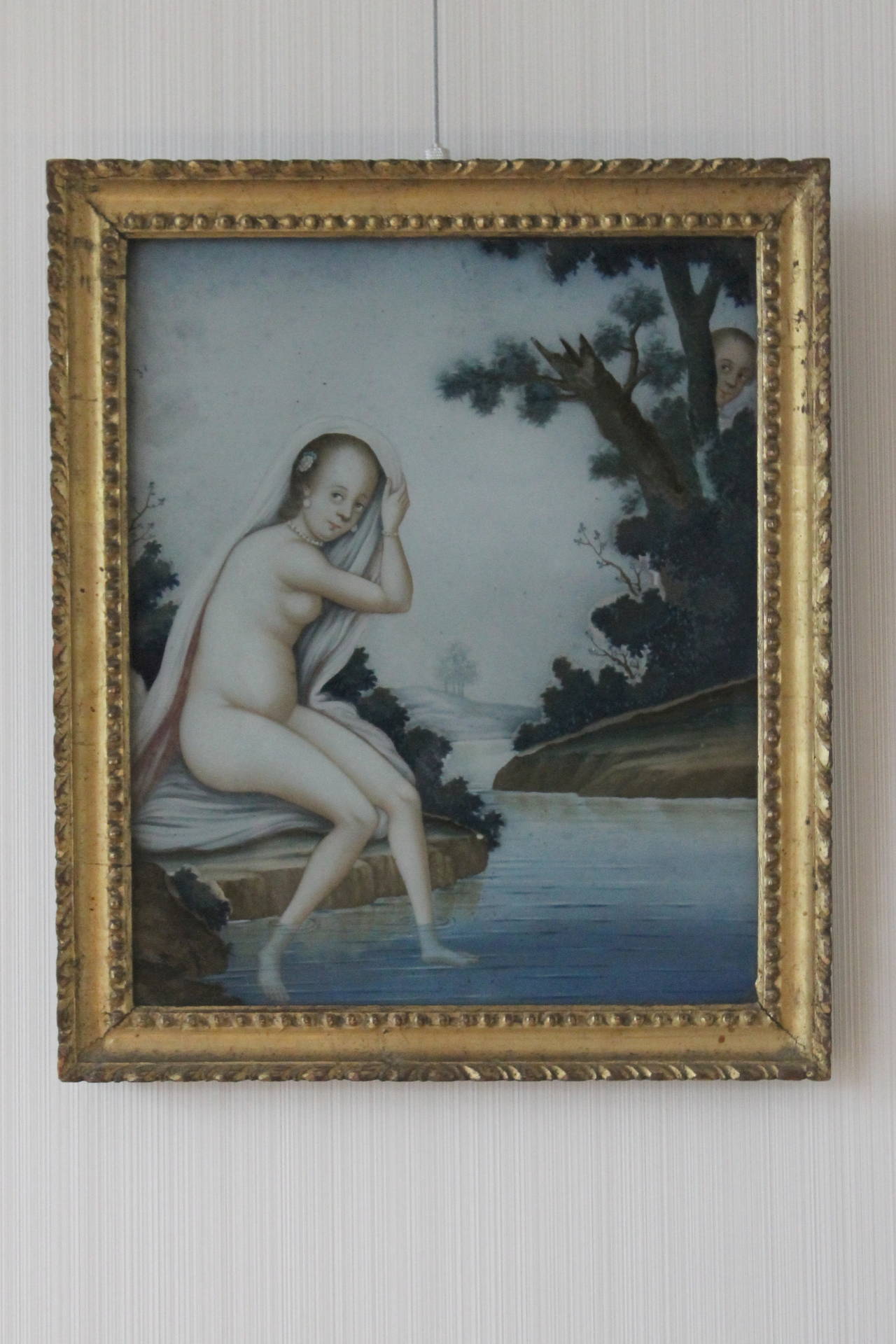 Pair of Chinese export European subject reverse paintings on glass, each painted with a lady bathing at the side of the river with her feet below the water line, one with her washing her feet, the other with the lady drying her hair beside rockwork