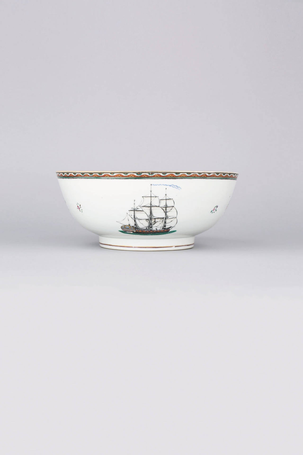 Famille rose punch bowl, painted with a Hudson Bay Company factory, probably at York, Canada, with an English blue ensign and typical stained glass windows, pitched roof and chimneys, in blue, pale turquoise, ruby and white enamels heightened with