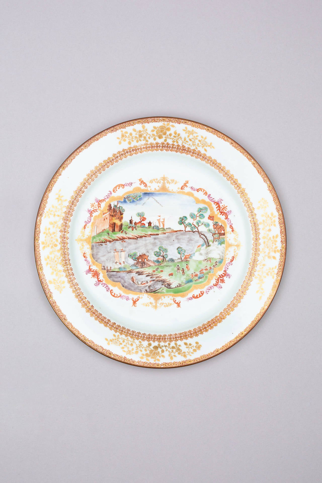Famille rose large circular tureen, cover and stand, after the Meissen original, each piece painted with a scene depicting European figures on grassy slopes along the banks of an estuary, some carrying bales of cargo, others in ships, with buildings