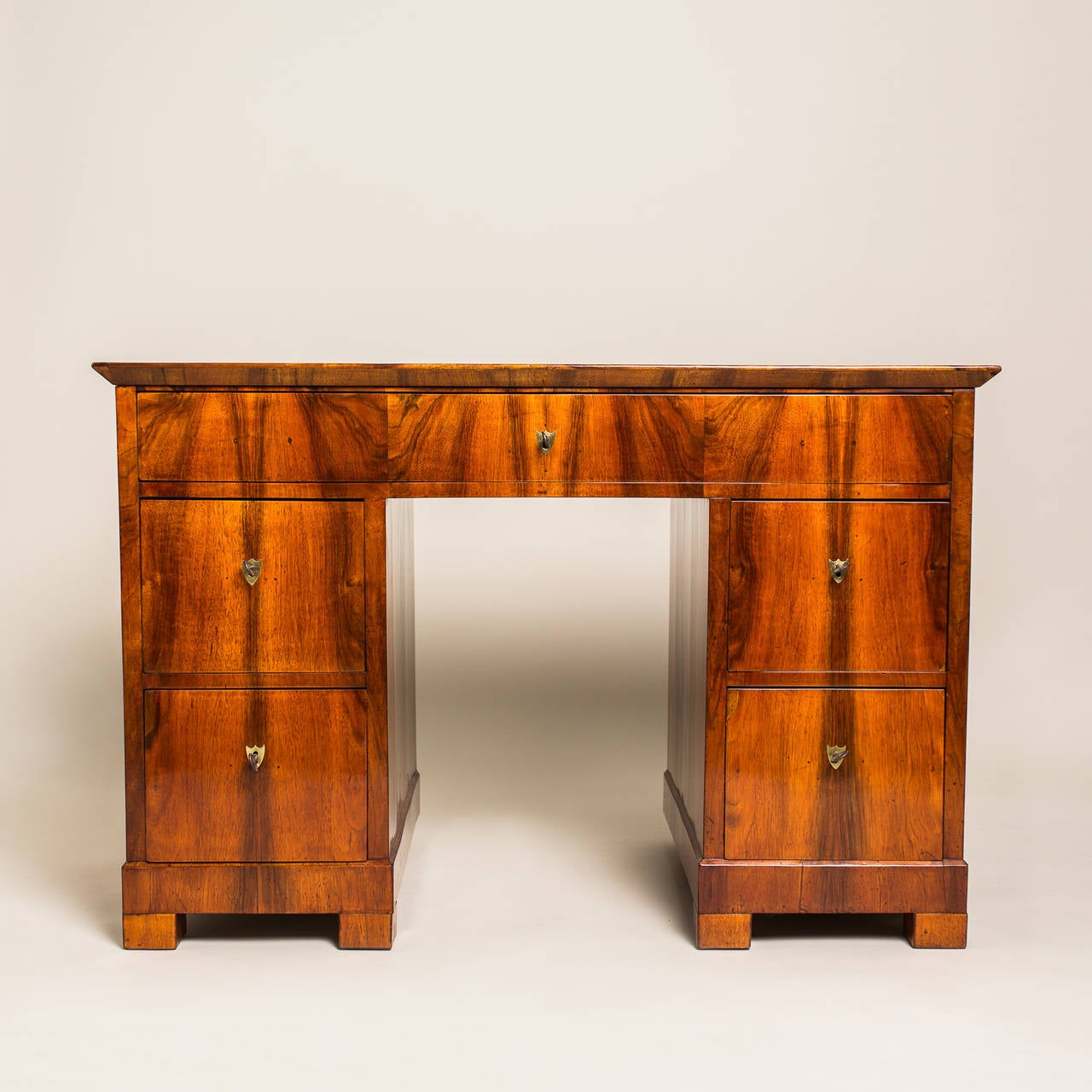 This exceptional Biedermeier writing desk hailing from Austria, circa 1830, has a compact but very handsome look. The rectangular corpus with great arranged walnut wood veneer, features a spacious drawer at the top and two deeper drawers on opposite
