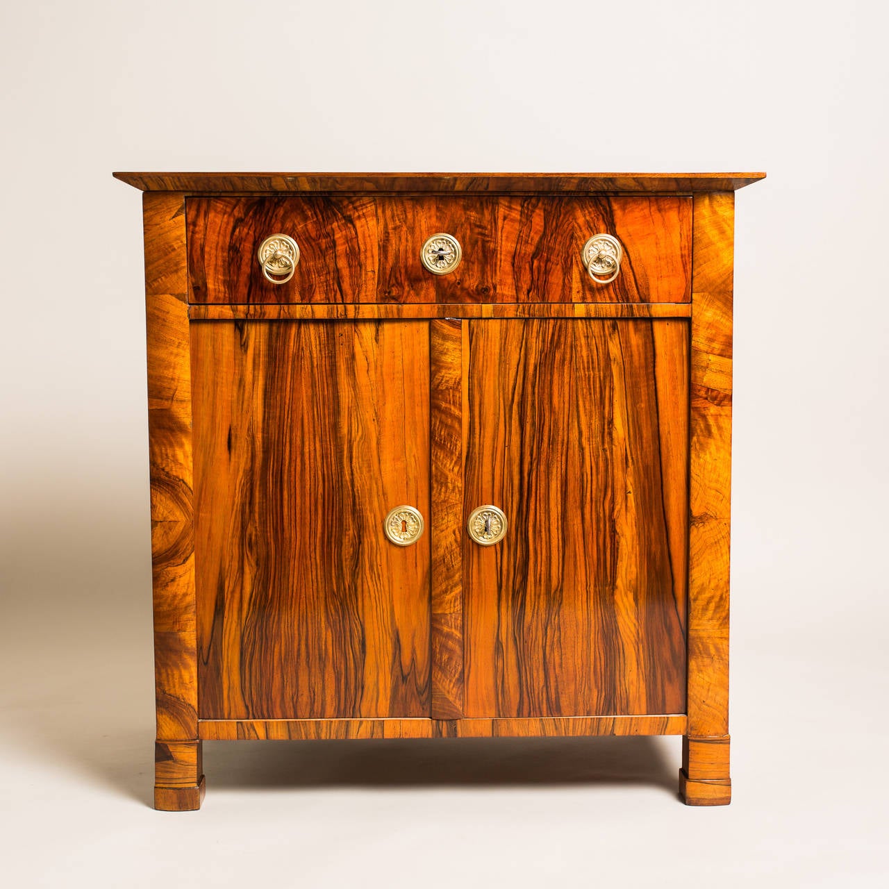 An antique item from the Biedermeier period that blends well in any context due to its simple yet charming minimalistic appearance. It was constructed from spruce wood, circa 1835, and veneered with walnut for a wonderful allure. The drawer sits