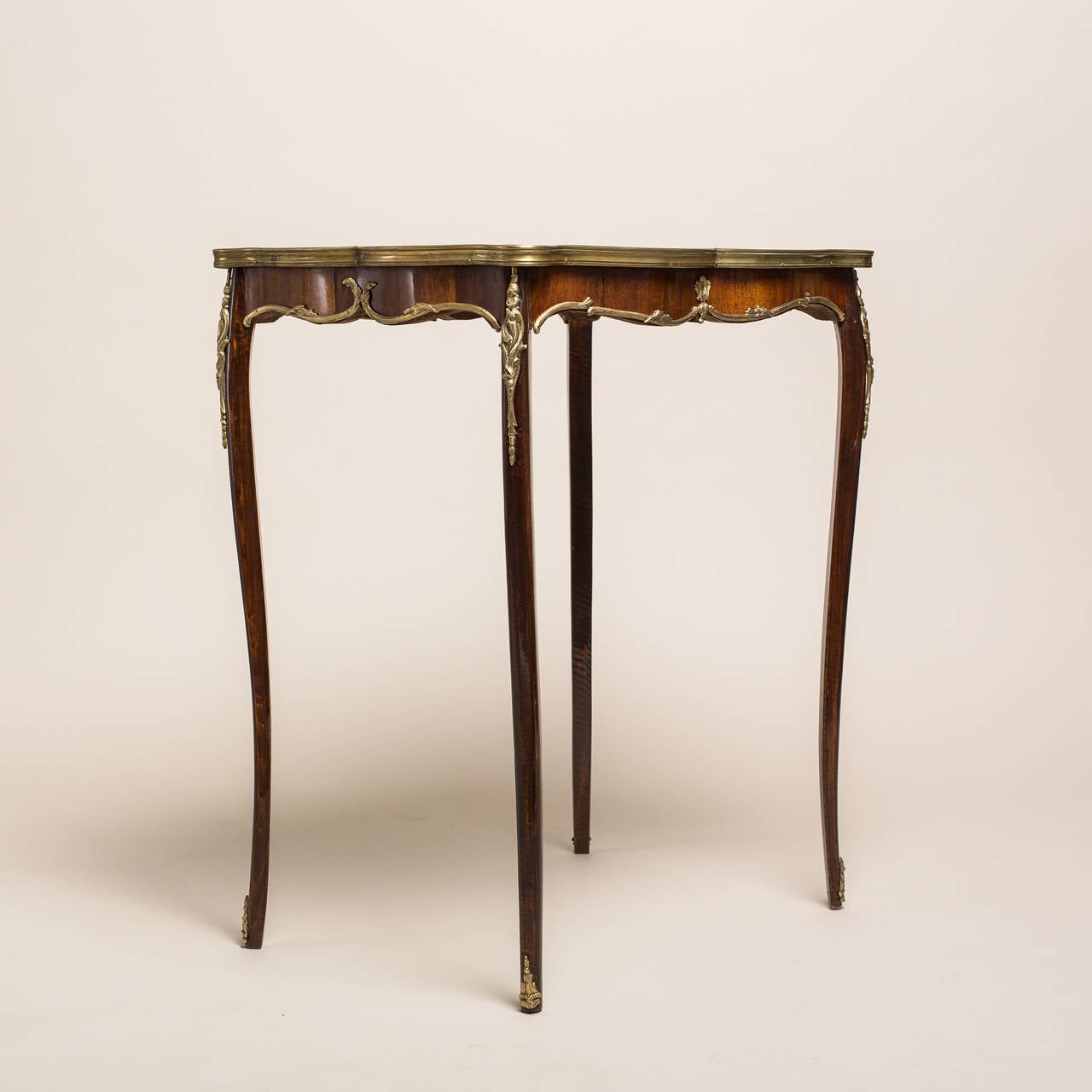 This petite amazing French Side Table comes out of the Napoleon III period, circa 1890. It leaves a lasting impression with its many delicate and superbly processed details. The top of the table has maple thread inlays decorating a rosewood or