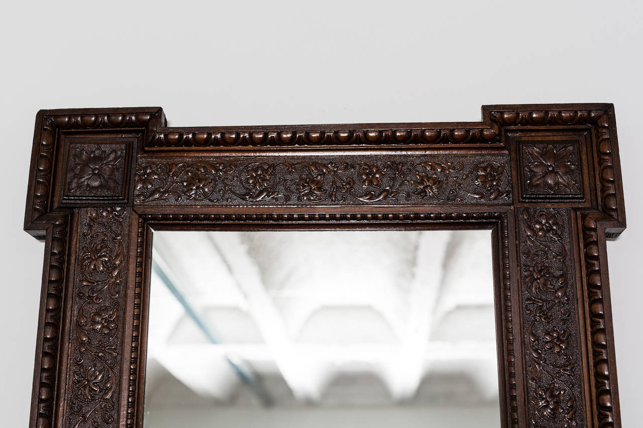 Manufactured in Austria, this beautifully appointed mirror dates to around 1880 (the Historicism period). Its main characteristic is an intricately elaborate pattern on its dark brown frame. The arresting pattern is surrounded by symmetrical and