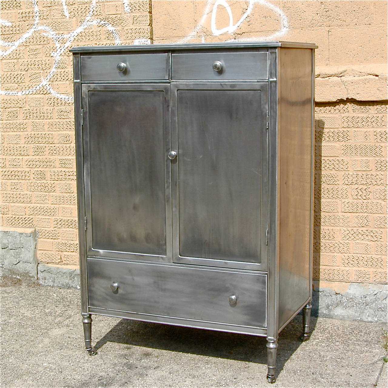 Rare, 1920's, brushed steel, gentleman’s chest by Simmons And Company offers hidden multiple storage drawers