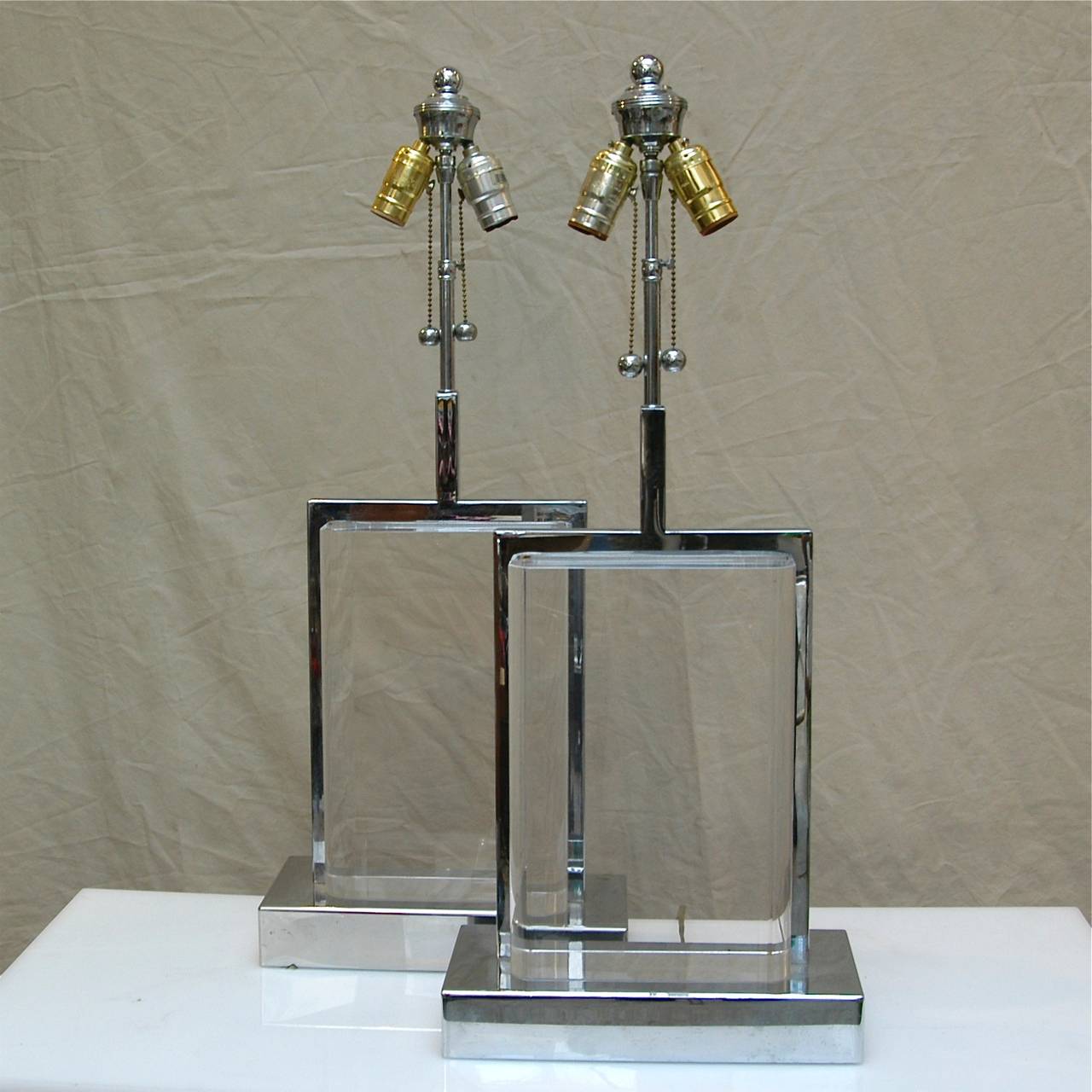 Pair of modernist, chrome and solid, clear Lucite table lamps by Karl Springer