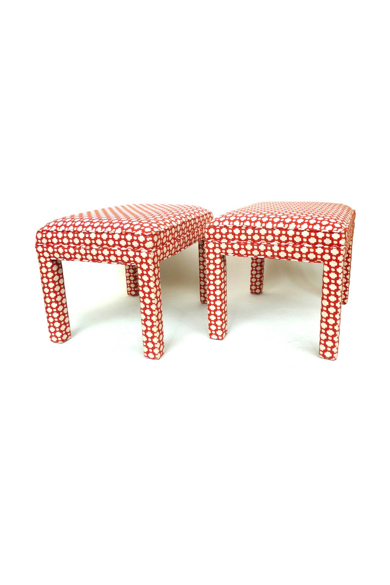 These bench ottomans are custom-designed by Celerie Kemble. The richly textured orange-and-white upholstery is Schumacher fabric and covers the entire surface of each bench. The pair is comfortably cushioned. They are perfect for a space in need of