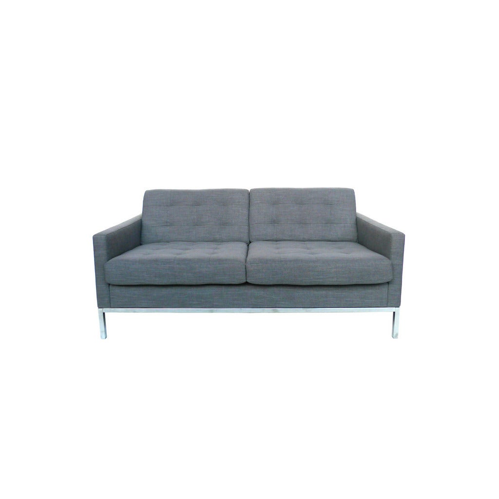 With the sleek and simple geometries that characterize Knoll furniture, this tufted settee is reupholstered with a blue gray cotton linen and sits on a polished steel frame.