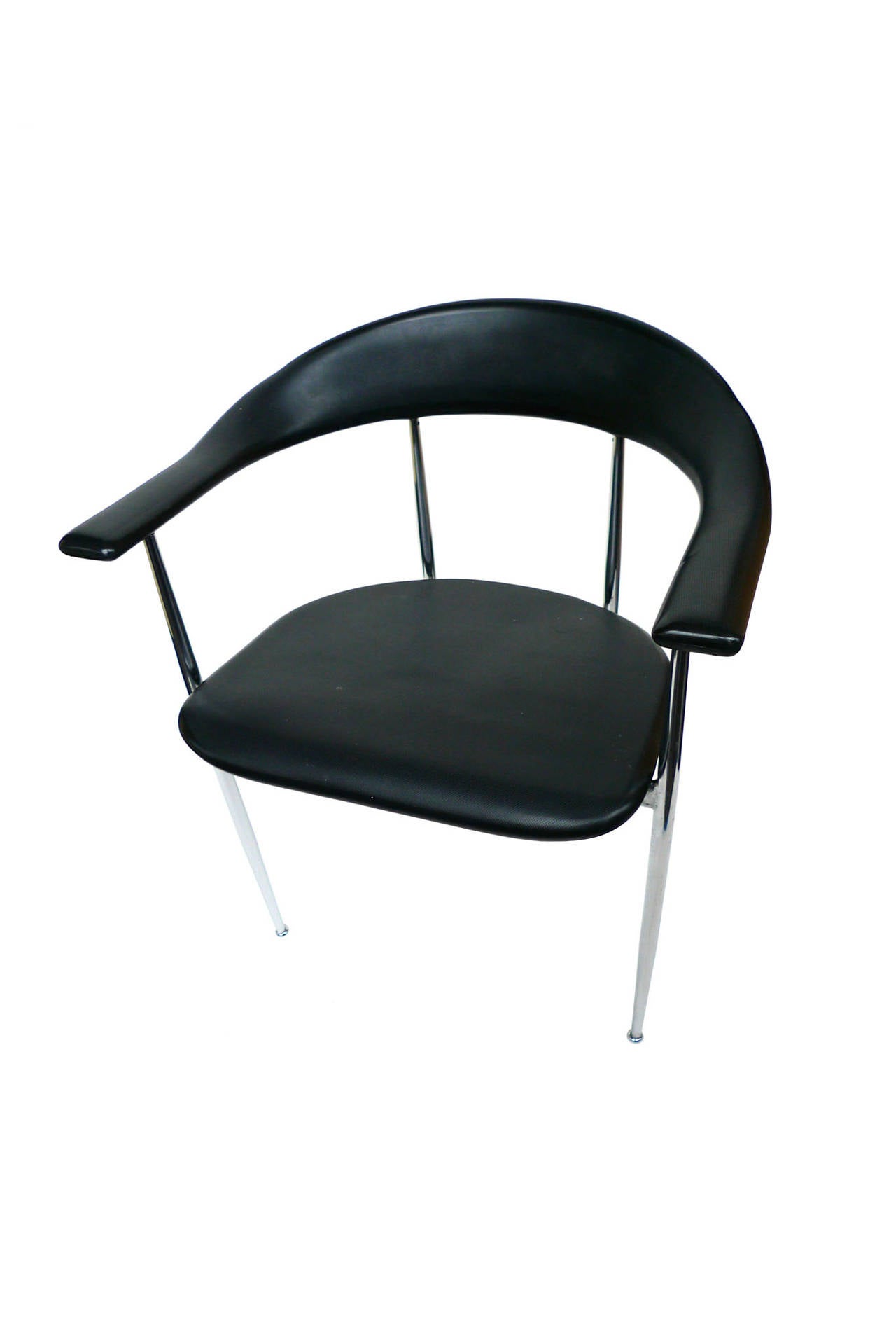 These minimalist Fasem dining chairs are comfortable and sturdy. The back and seat are molded black rubber, while the base and legs are chrome. Their design is noteworthy for the rounded edges, which accentuate the chairs' soft rubber material, and