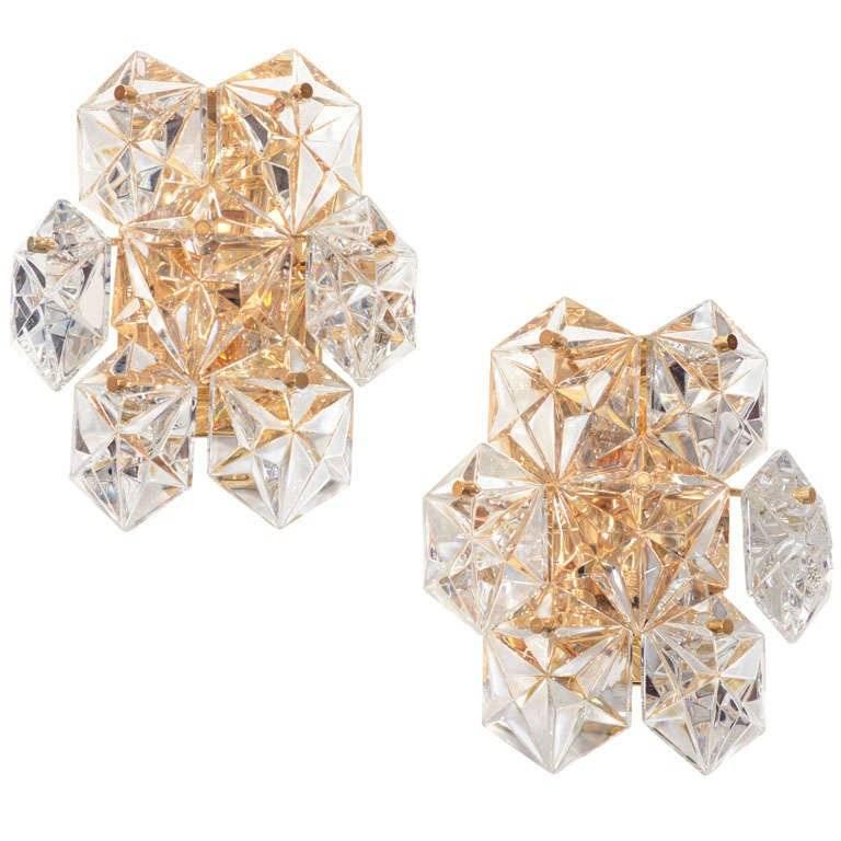 Außergewöhnliches Paar von Wandleuchtern in facettiertem Kristall auf 22-karätig vergoldeten Grundplatten. Jede Leuchte besteht aus sieben Kristallprismen und zwei Lampenfassungen.