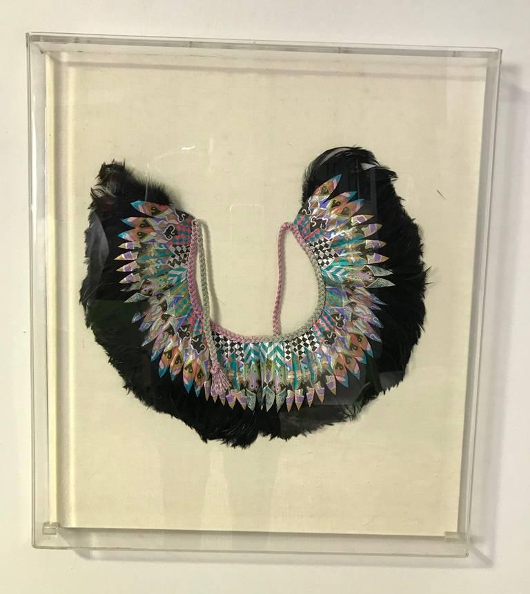 A beautifully designed, decorative and stunning feather and fabric collar by famed fashion designer K. Lee Manuel. The piece has been professionally mounted and artfully framed in an acrylic box frame. It really stands out. Very riveting piece of