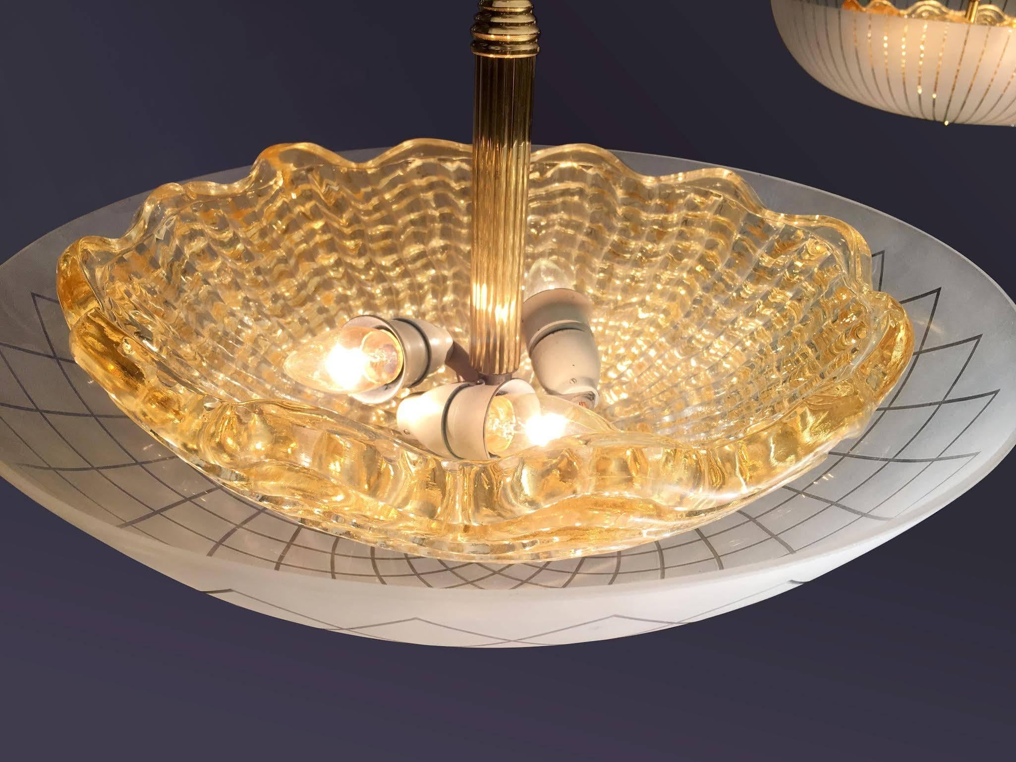 An etched glass chandelier with thick amber inner bowl with fluted brass rod and brass hardware by Orrefors.

Swedish, Circa 1940's