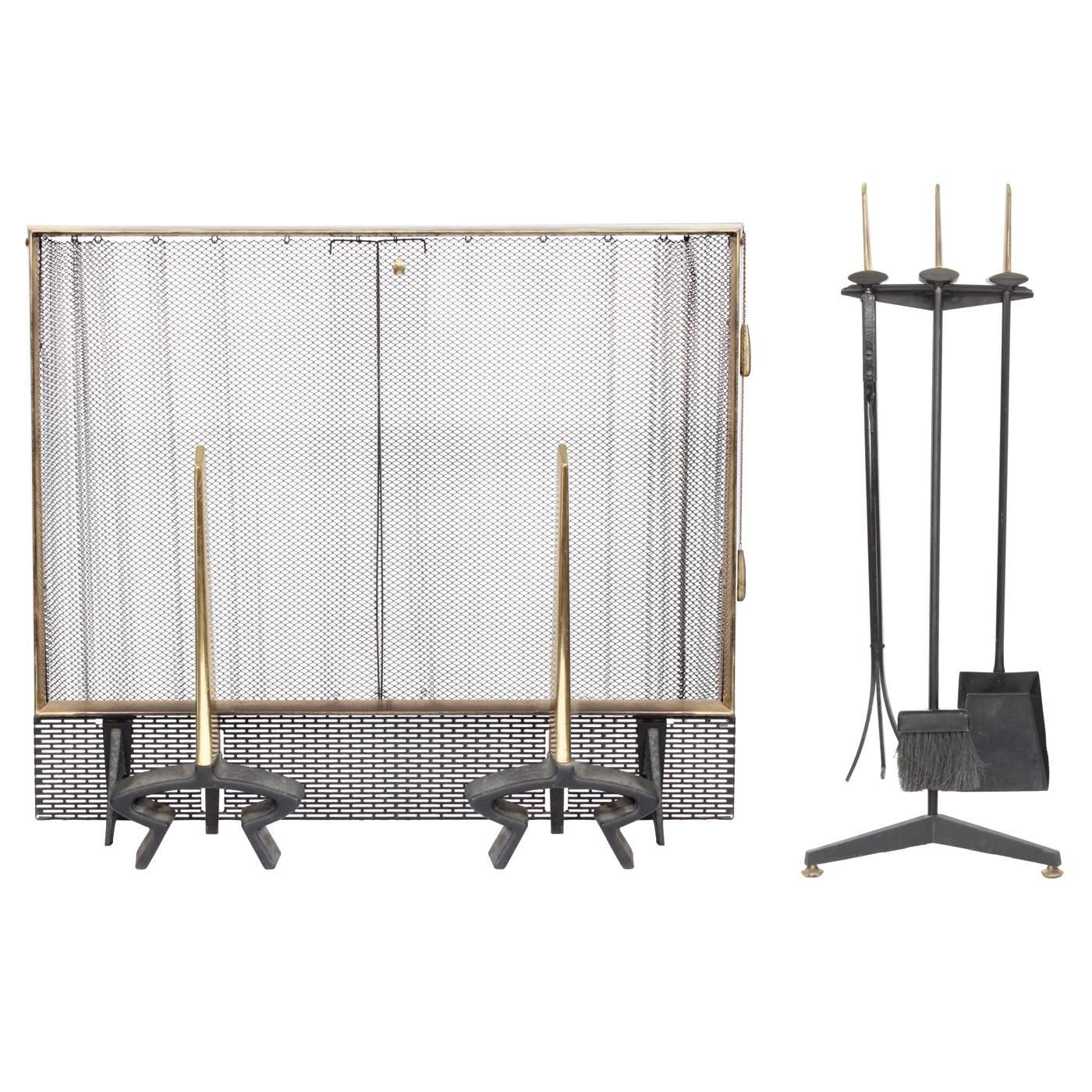 Wrought iron and brass fireplace set (andirons and screen) by 
Donald Deskey for Bennett, American, 1950s. The brass has a beautiful patina.

Screen dimensions: 
29 inches high x 34 inches wide x 7 inches deep. 

Andiron dimensions: 
19