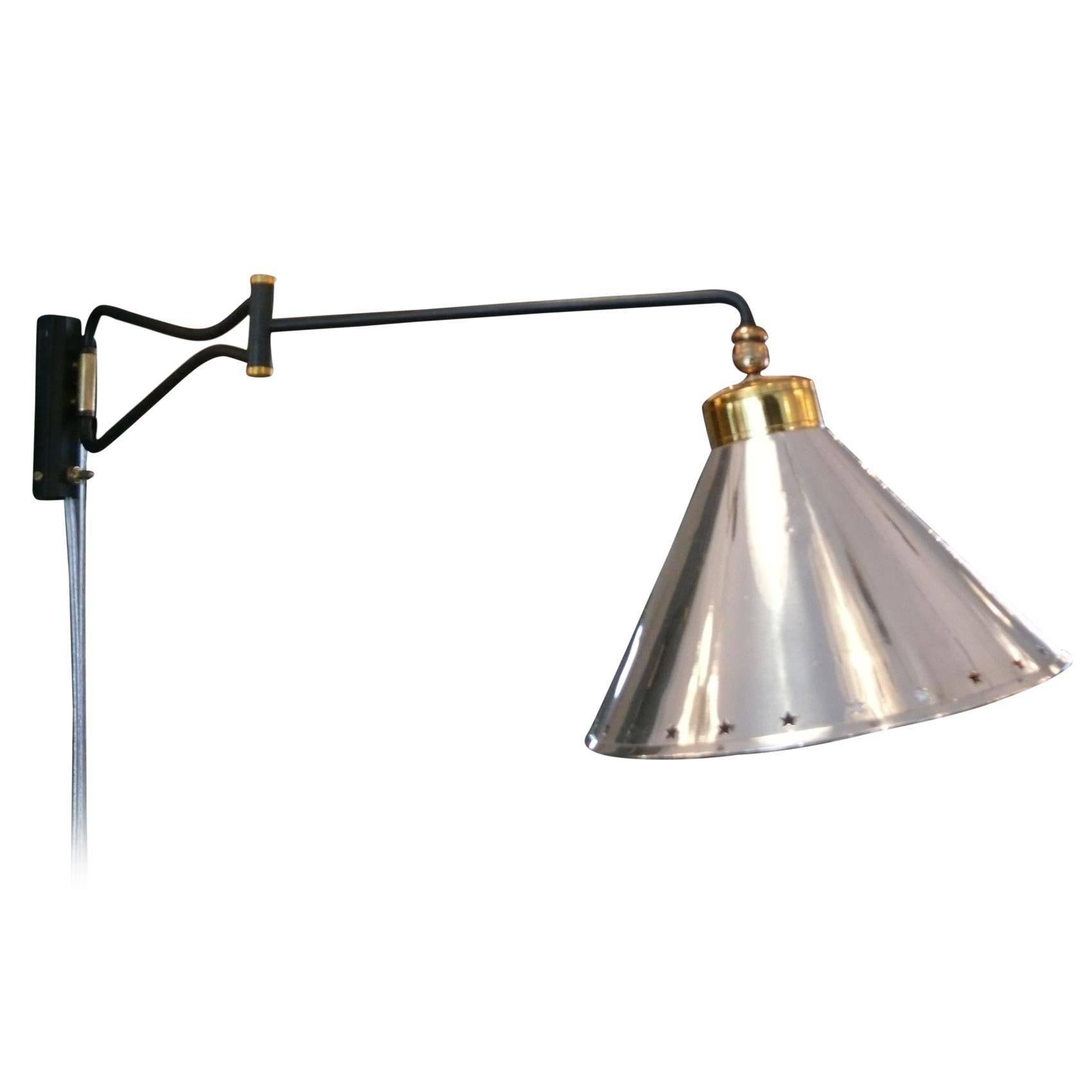 Lunel articulating arm sconce with polished aluminum shade with perforated star detailing and brass hardware. Shade pivots and articulates. Professionally rewired.