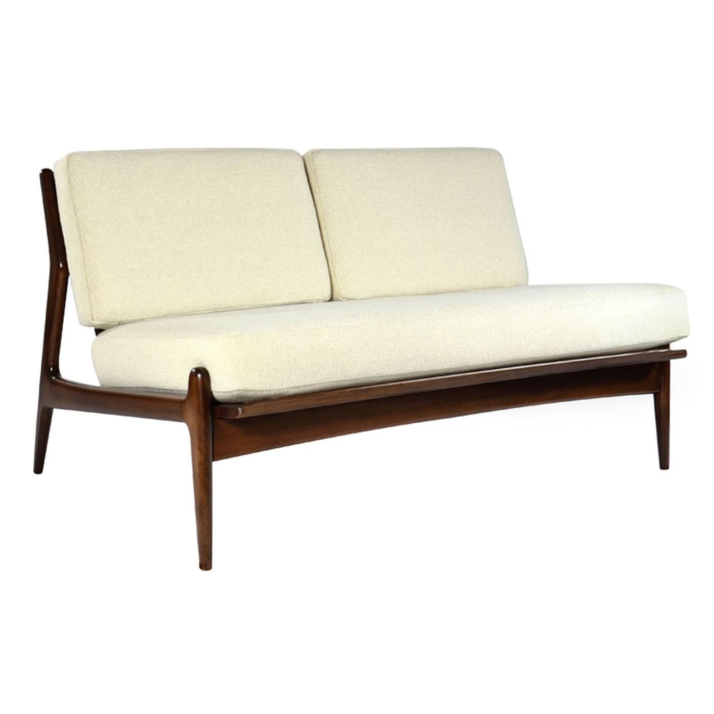 A rare Poul Jensen for Selig armless loveseat or settee, manufactured in Denmark, circa 1950s.

Newly upholstered in ivory tweed. Fully restored to its original medium walnut tone.