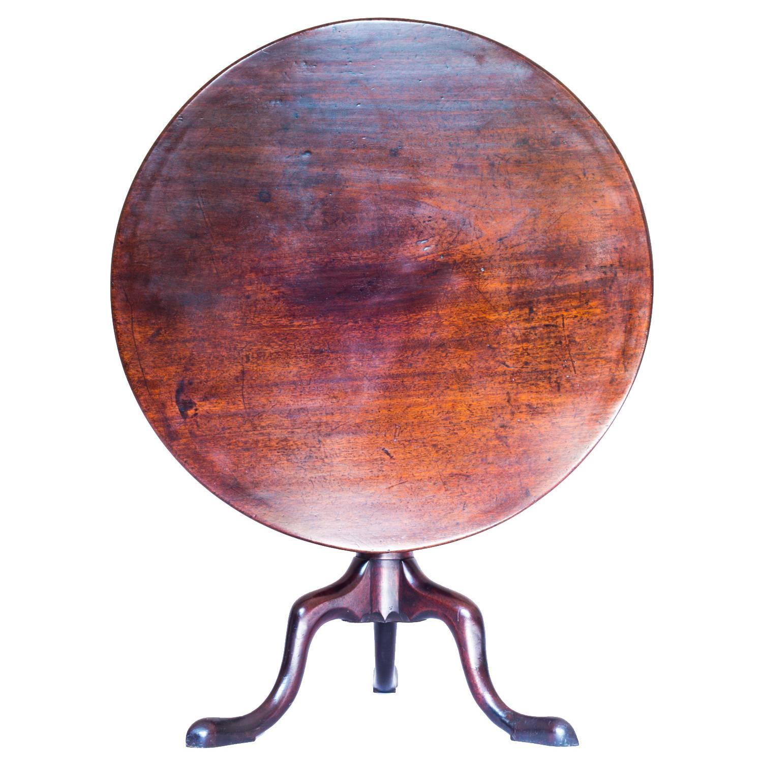 A superb George II period occasional tilt-top table, in heavy and dense Cuban mahogany,

English, circa 1750.

The round solid top, cut from a single trunk of dense and well grained Cuban mahogany, above a tapering standard having a lower spiral