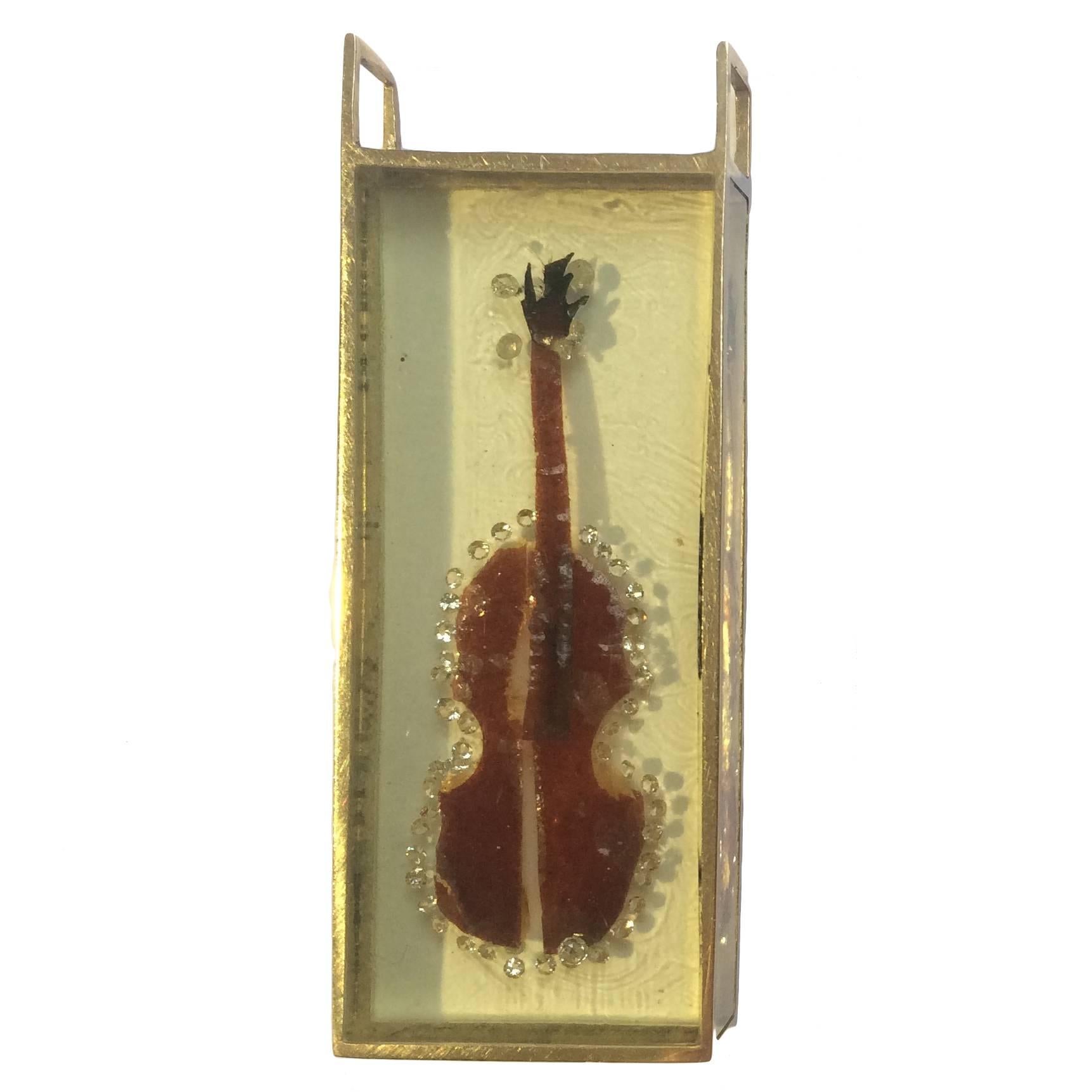 Hand made pendant by Arman in 1973.
Yellow gold casing cutout violin shape from varied beetle species with diamonds embedded in resin.
Unique

Arman is a painter who moved from using objects for the ink or paint traces they leave (