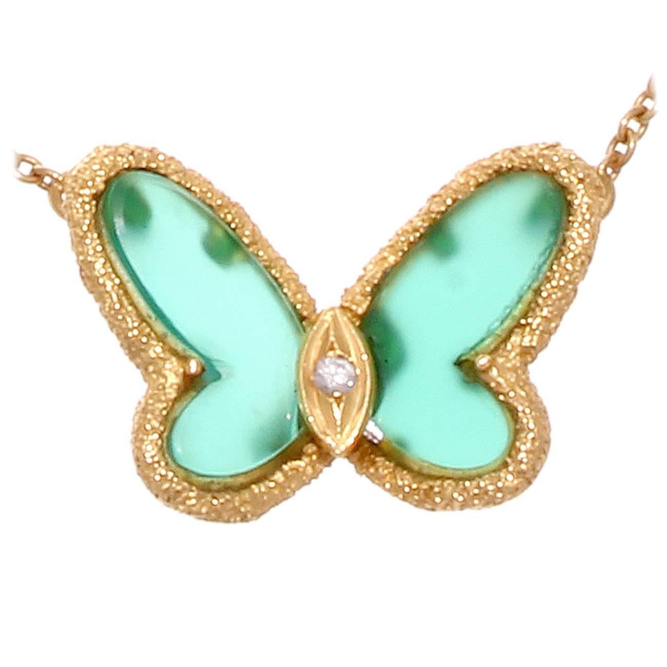 The elegantly floating designed butterfly has color and style. Featuring green wings of chalcedony outlined with textured 18k yellow gold and a body featuring a lone white diamond. Signed VCA, numbered and stamped with French hallmarks. 

