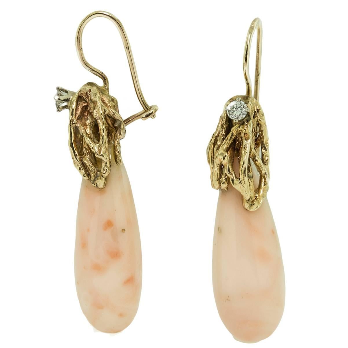 These charming earrings are set in 14kt yellow gold. Each earring is embellished by a tiny .05 diamond. The gold work is  free form and designed as  naturalistic looking coral. The colour variations are naturally occurring within the coral.The