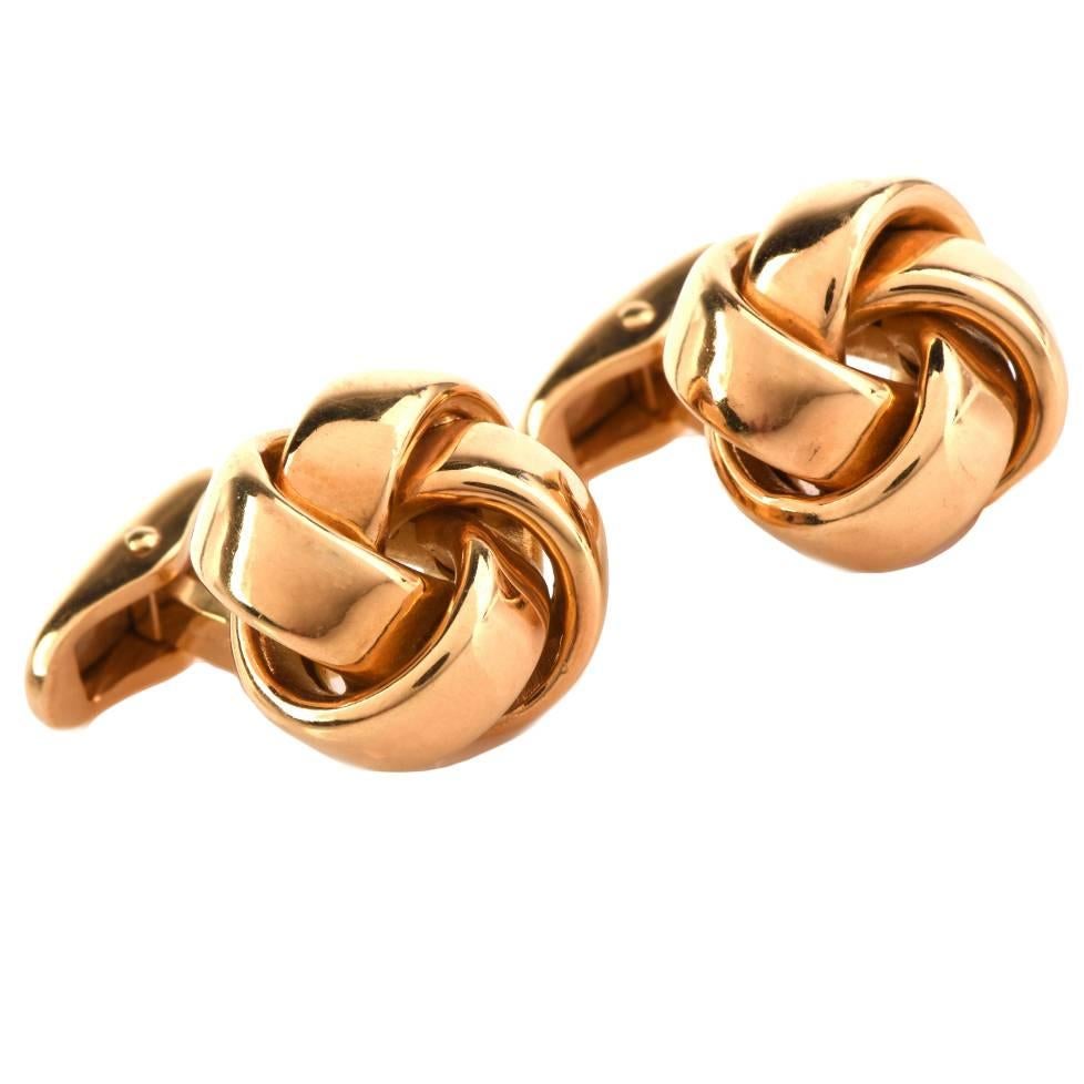 These classically distinct cuff-links crafted in solid 18K yellow gold are of German provenance, weigh 15.7 grams and measure 17 mm wide. They incorporate interwoven scrolls, creating a stylized high polished knot pattern. The are engraved with the