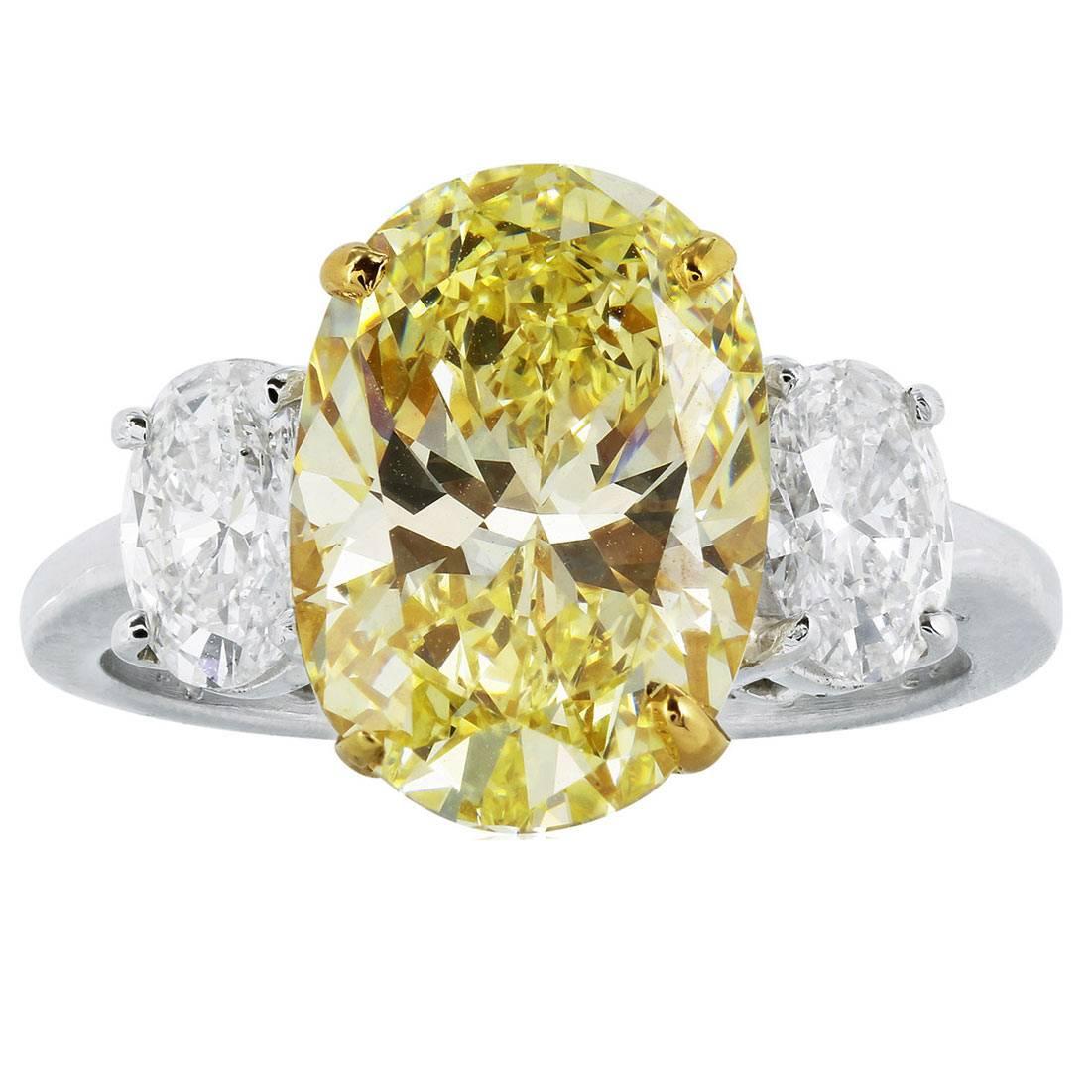 4.55 Carat GIA Cert Oval Shaped Canary Diamond Gold Platinum 3 Stone Ring For Sale