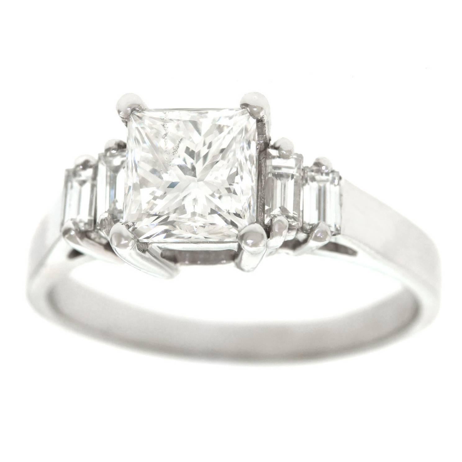 Circa 1990s, platinum, American.  A modern classic, this five-stone engagement ring is set with a brilliant white 1.51 carat princess-cut diamond (GIA report, G color, SI2 clarity) surrounded by .30 carat of baguette diamonds (H-G color, SI1