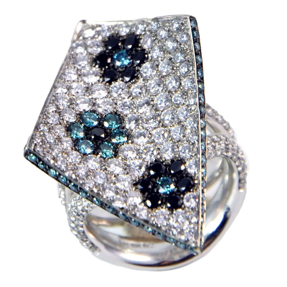 Bague contemporaine en or blanc 18Kt sertie de 4,25 carats de diamants blancs, bleus et noirs sertis en pavé. Les mesures approximatives de cette bague fabriquée en Italie  sont énumérés ci-dessous.
Signé, poinçons français et italien

