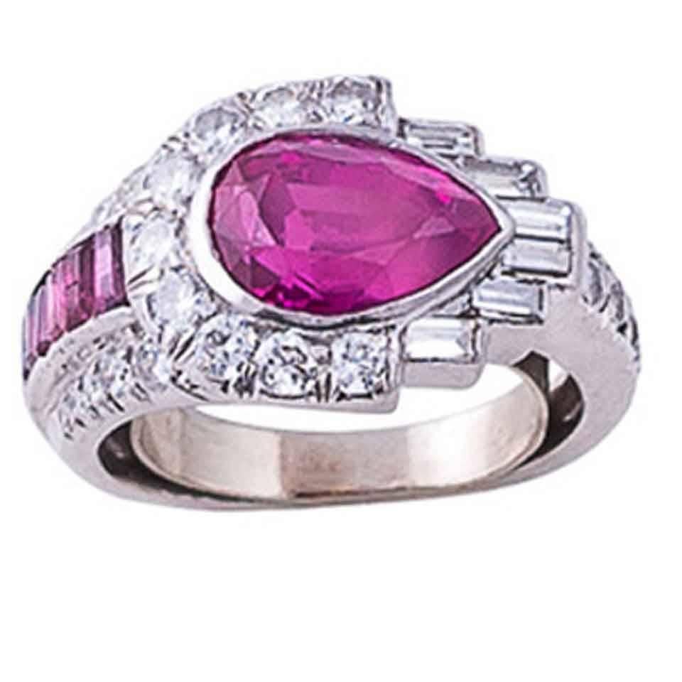 This original, stunning ring centers 1 bezel-set 3.0 carat non heat-treated pear-shaped ruby surrounded on one side by 9 bead-set round brilliant-cut diamonds and the other by 6 bezel-set baguette-cut diamonds. One shoulder is set with 5 old