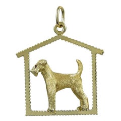 Une breloque en or représentant un chien dans une maison de chien