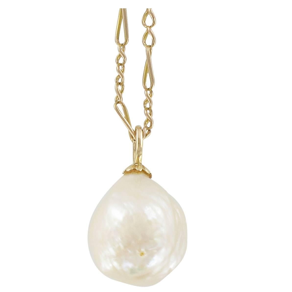 Pendant in 18 carat yellow gold, eagle head hallmark
This gold pendant necklace features a pinkish white oriental blister pearl. It is supplied with its curb chain with a snap hook clasp.  
Size of the pearl: 1.5 cm x 1.3 cm.
Length of the chain: 41