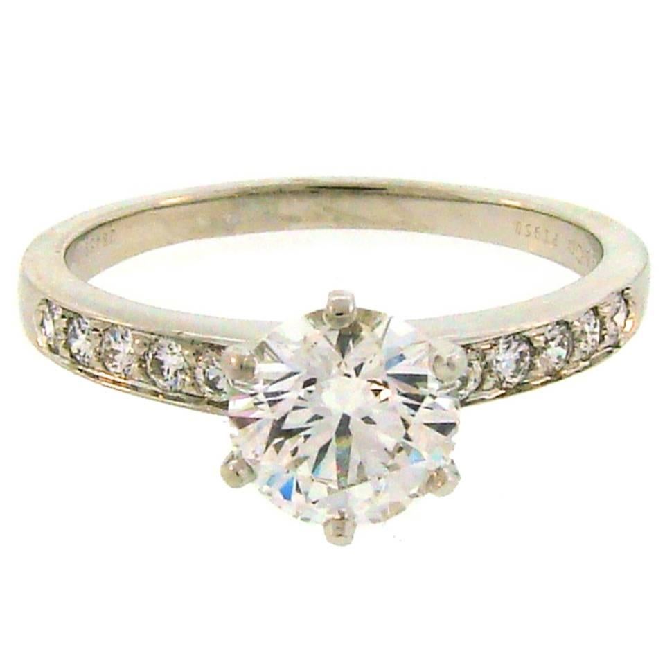 Classic Tiffany & Co. diamond & platinum engagement ring. Features a very fine quality 1.50-carat round brilliant cut diamond accented with ten round diamonds on the sides. The center diamond has a Tiffany Gemological Laboratory Report