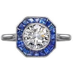 Brilliant cut millegrain set diamond with calibre cut sapphire surround 9