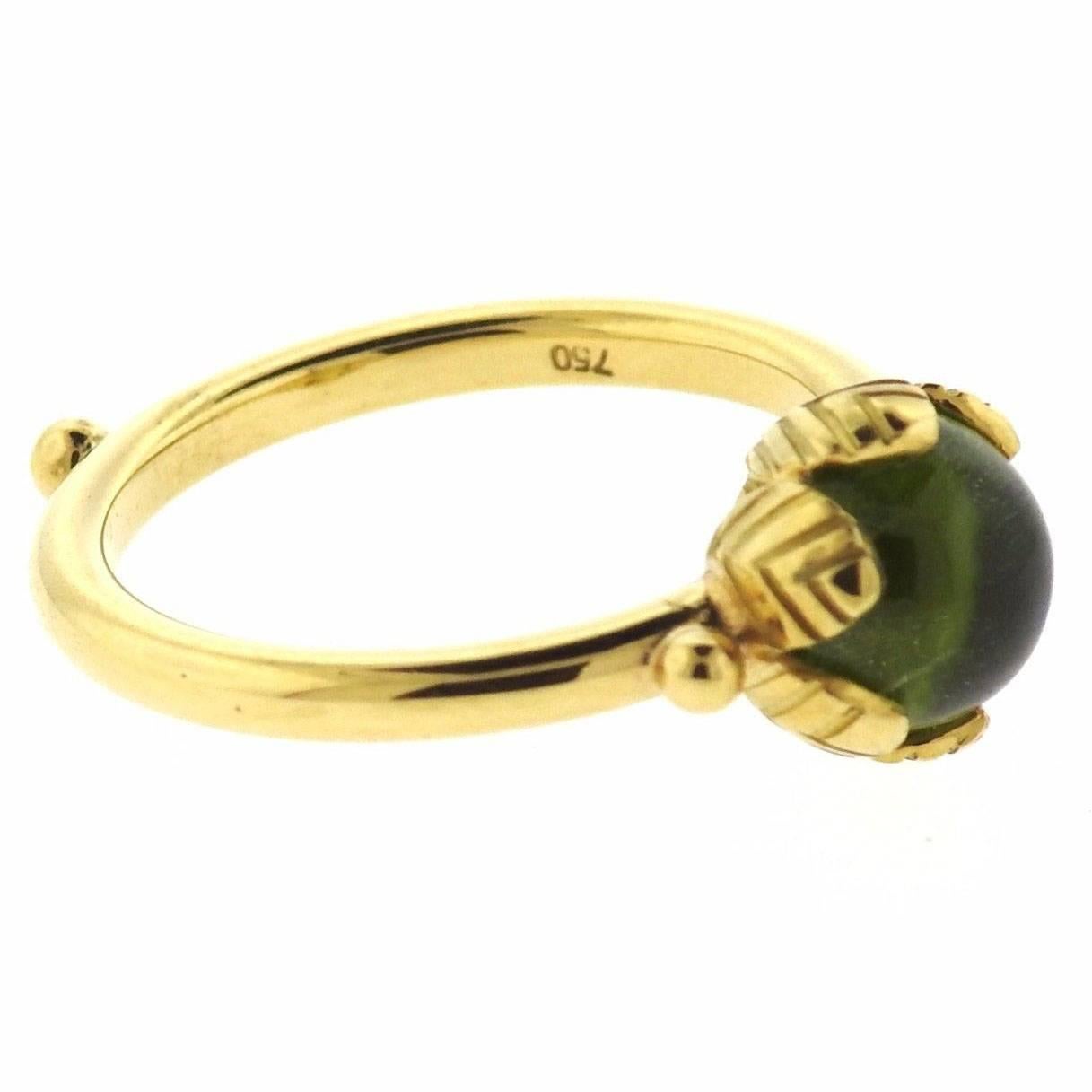 An 18k yellow gold ring set with peridot.  The ring is a size 7.25, ring top is 9.5mm in diameter.  Marked: Temple Mark.  The weight of piece 1311 grams. Retail is $1950.