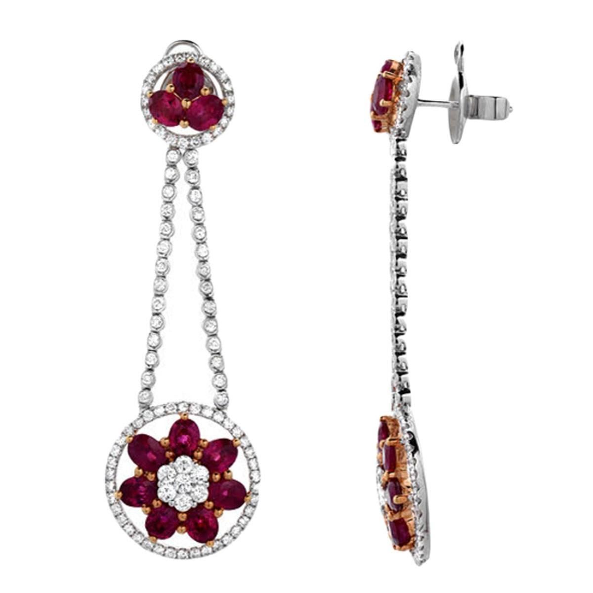 A feminine pair of earrings featuring 8.82 carats of oval shaped vivid red rubies and 2.96 carats of VS quality round cut diamonds. The pendulum style earrings have a soft movement to them, set in 18K gold.

Earring Length: 2.45 inches
Earring