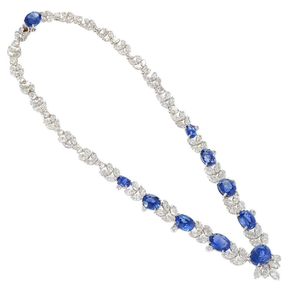 This glorious late 20th century sapphire and diamond necklace is a modern interpretation of the garland necklace, set with magnificently radiant, cornflower blue oval-cut sapphires and colorless diamonds. Encircling the collarbone in a lavish floral