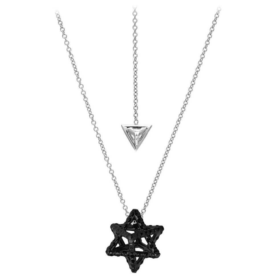 Black-finished platinum Merkaba star necklace, featuring a total of approximately 0.97 carats of round brilliant black diamonds. This heirloom-quality, three dimensional, sacred geometric jewelry piece, suspends elegantly at the chest, measuring
