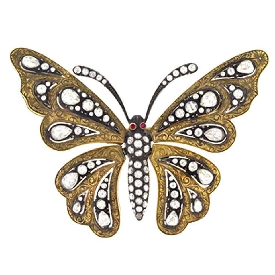 The body and antennae of the butterfly are bead-set with rose-cut and single-cut diamonds with 2 bezel-set ruby eyes, the wings are intricately engraved gold bead-set with round and pear-shaped rose-cut and single-cut diamonds and are movable (set
