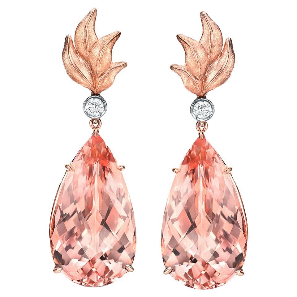 Morganite earrings, featuring a pair of enticing 31.63 carat total Morganite pear shapes, suspended from a pair of 0.19 carat total round brilliant diamonds.
Crafted in 18K rose gold and 18K white gold.
Total length: 1.75