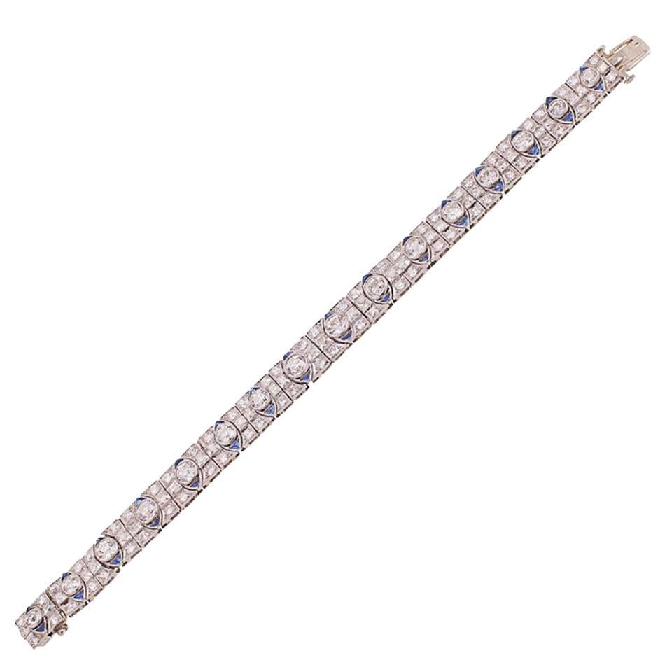 The flexible bracelet is composed of 16 uniform links, each centering 1 bezel-set old European-cut diamond flanked vertically on either side by 1 triangular-shaped sapphire, and horizontally by 1 bezel-set French-cut diamond, each corner bead-set