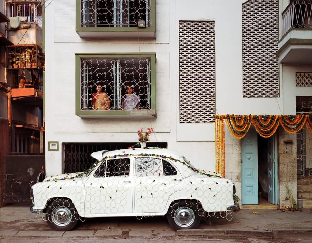 Laura McPhee Color Photograph - Ambassador Car Decorated for a Wedding by a Net Strung with Fresh Flowers