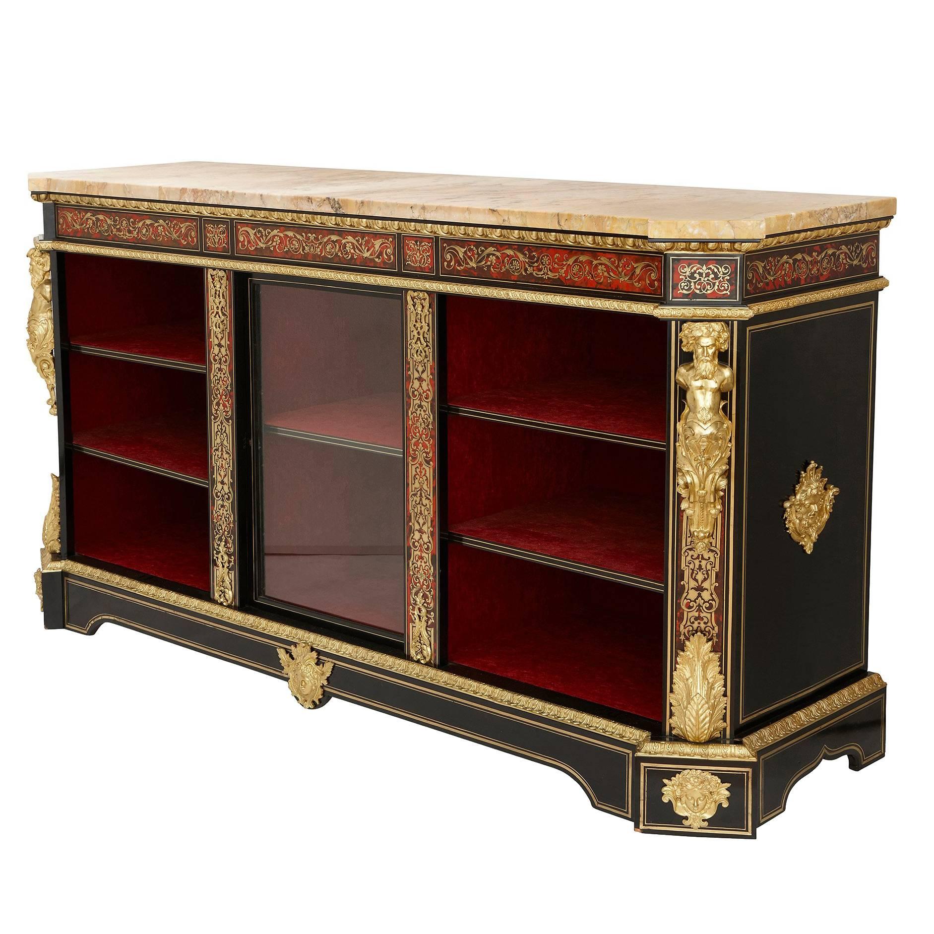 The stunning cabinet in the Napoleon III style and of the sam period, featuring inlaid Boulle work panels of brass and fine scarlet tortoise shell, with cast ormolu mounts depicting mouldings of acanthus leaves and two torsos of a male figure on