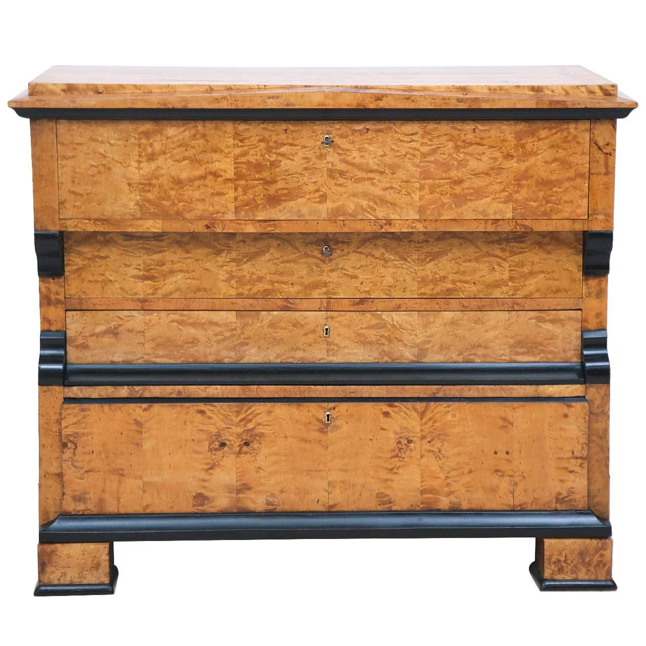 A very handsome birch Karl Johan Biedermeier chest of drawers with a drawer front fold down secretary. The drawer-front opens to an ample and beautiful ebonized and faux mahogany interior offering two letter drawers flanking the central cubby, which