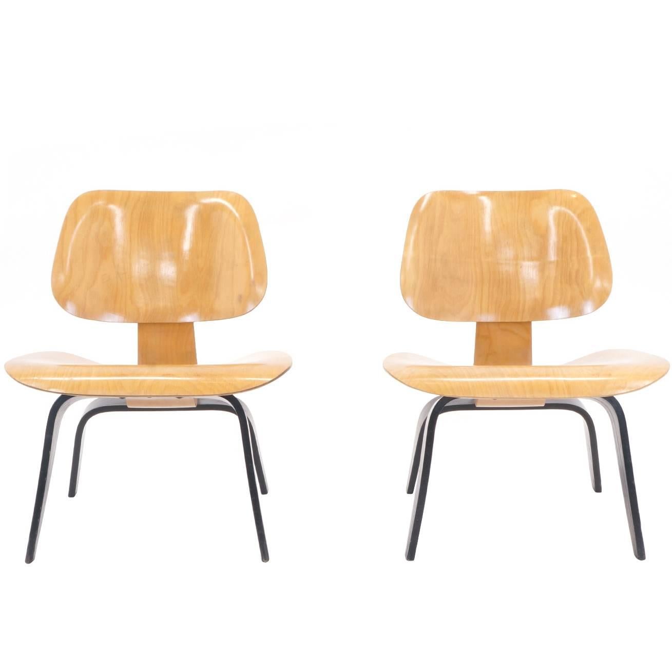 Very early pair of Eames lounge chairs, signed with Evans labels in excellent condition. Black aniline dyed legs and ash seats and backs. Beautiful examples of this design.