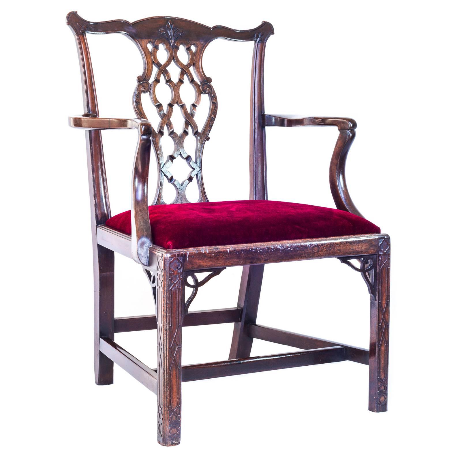 A superb example of George III Chippendale period armchair, in dense mahogany, generously proportioned, having a Gothic-inspired interlaced splat, blind fretwork carving to the front legs and pierced angle brackets to seat rails.

English, circa