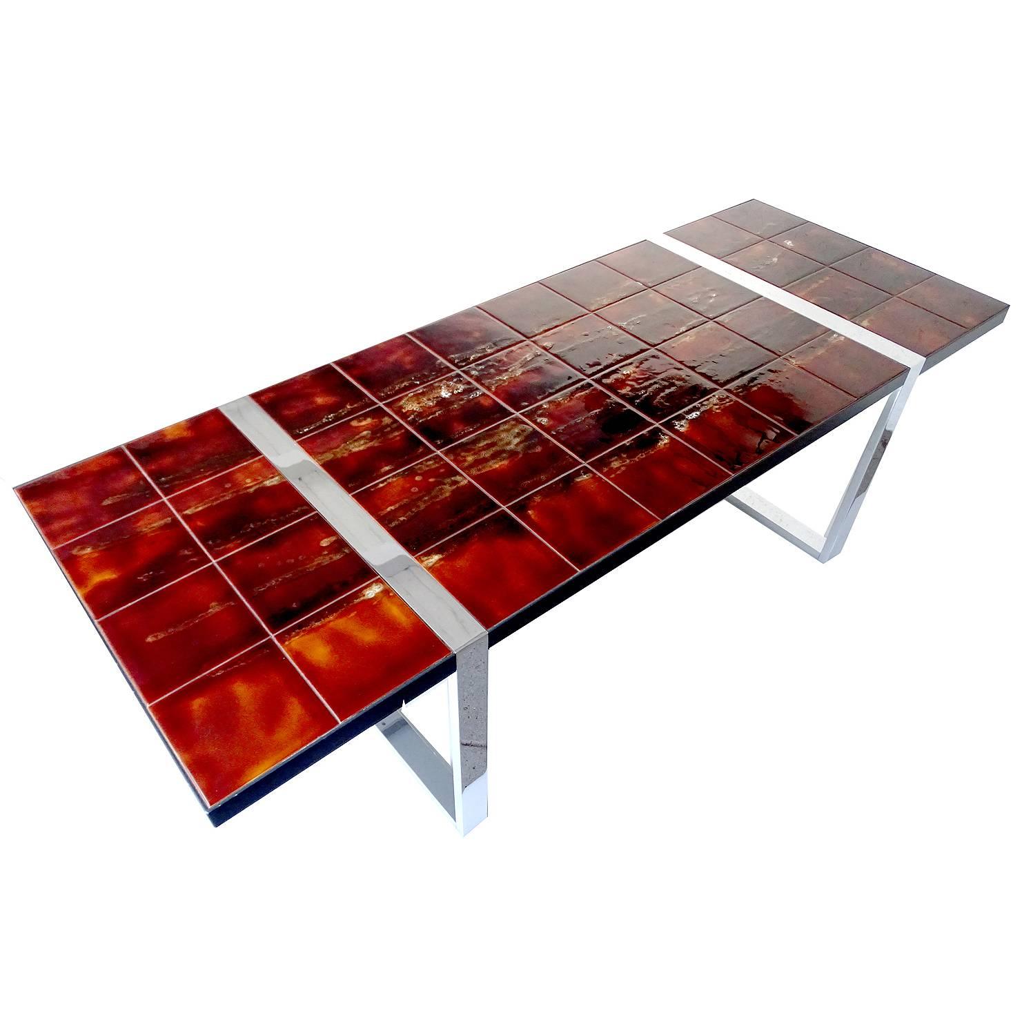 Large Mid-Century coffee or side table featuring handmade ceramic tiles supported by a chrome frame.

The original Spanish glazed tiles mounted on the tabletop were produced in flamed hues ranging from dark marron to a sienna yellow / orange and