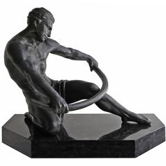Grande sculpture exquise Art Déco d'un homme semi-nu se penchant sur une barre sur une base en marbre