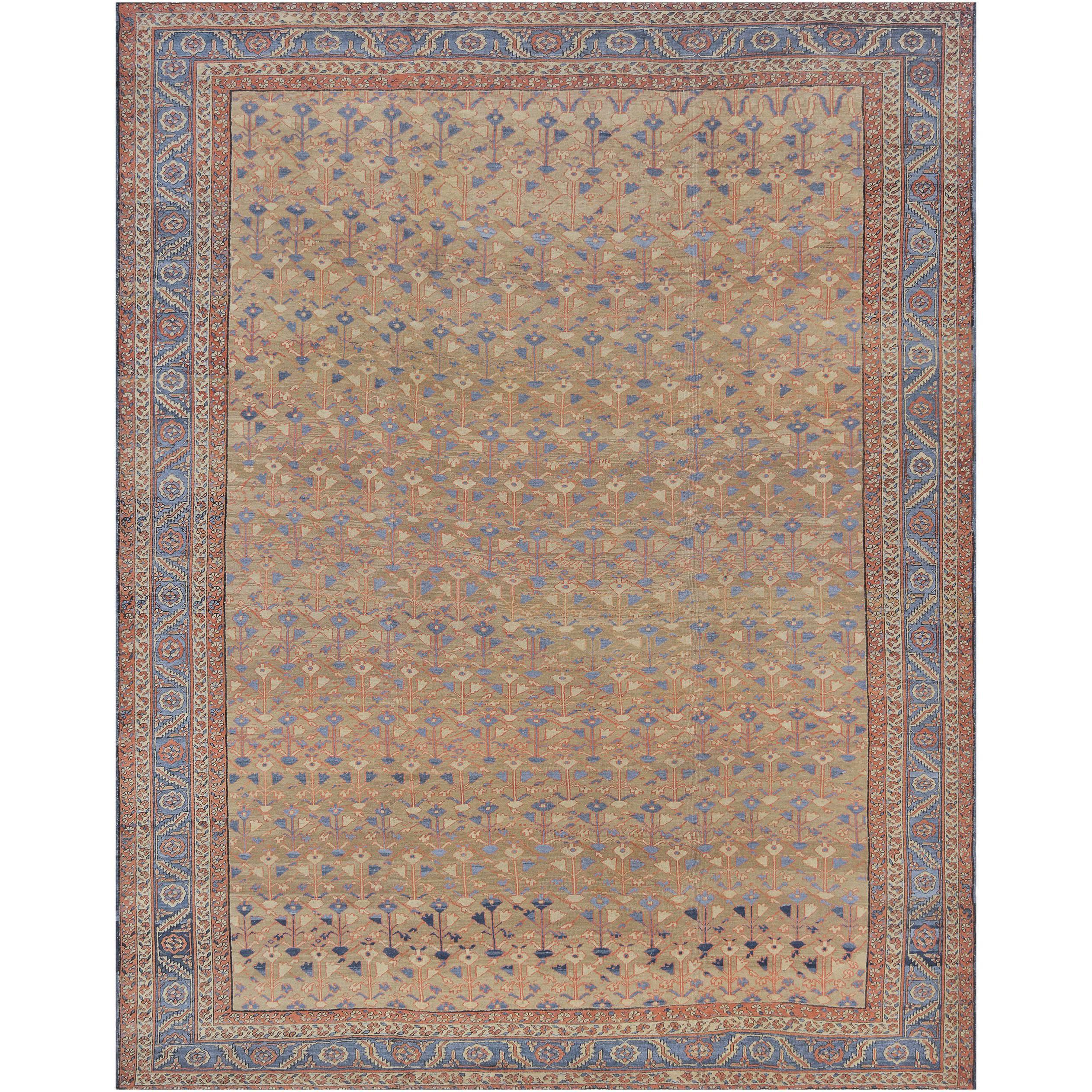 This traditional handwoven wool Persian Bakhshaish rug has a shaded beige overall field of stylized stalks issuing delicate floral motif forming an intricate vine network, in a gorgeous shaded sapphire scrolling palmette vine border, between
